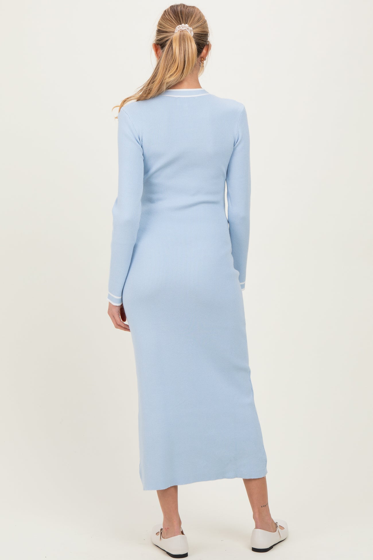 woman wearing a light blue long sleeve ribbed maternity dress from the back