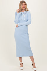 woman wearing a light blue ribbed midi dress with a tie neckline and long sleeves