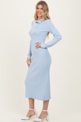 woman wearing a light blue ribbed midi dress with a bow tie detail at the neckline and long sleeves