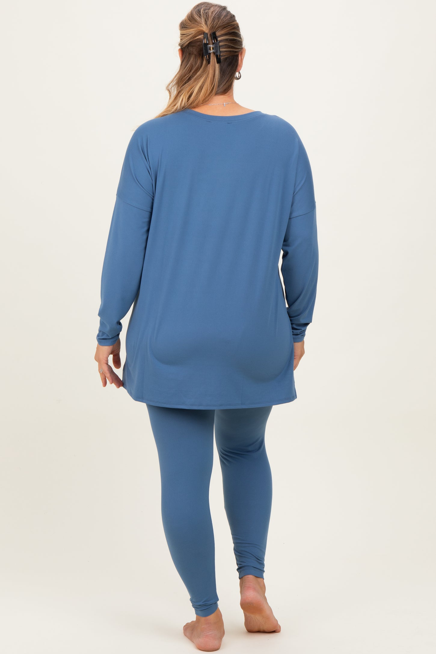 woman wearing a blue long sleeve maternity top and matching leggings, showing a relaxed fit from the back