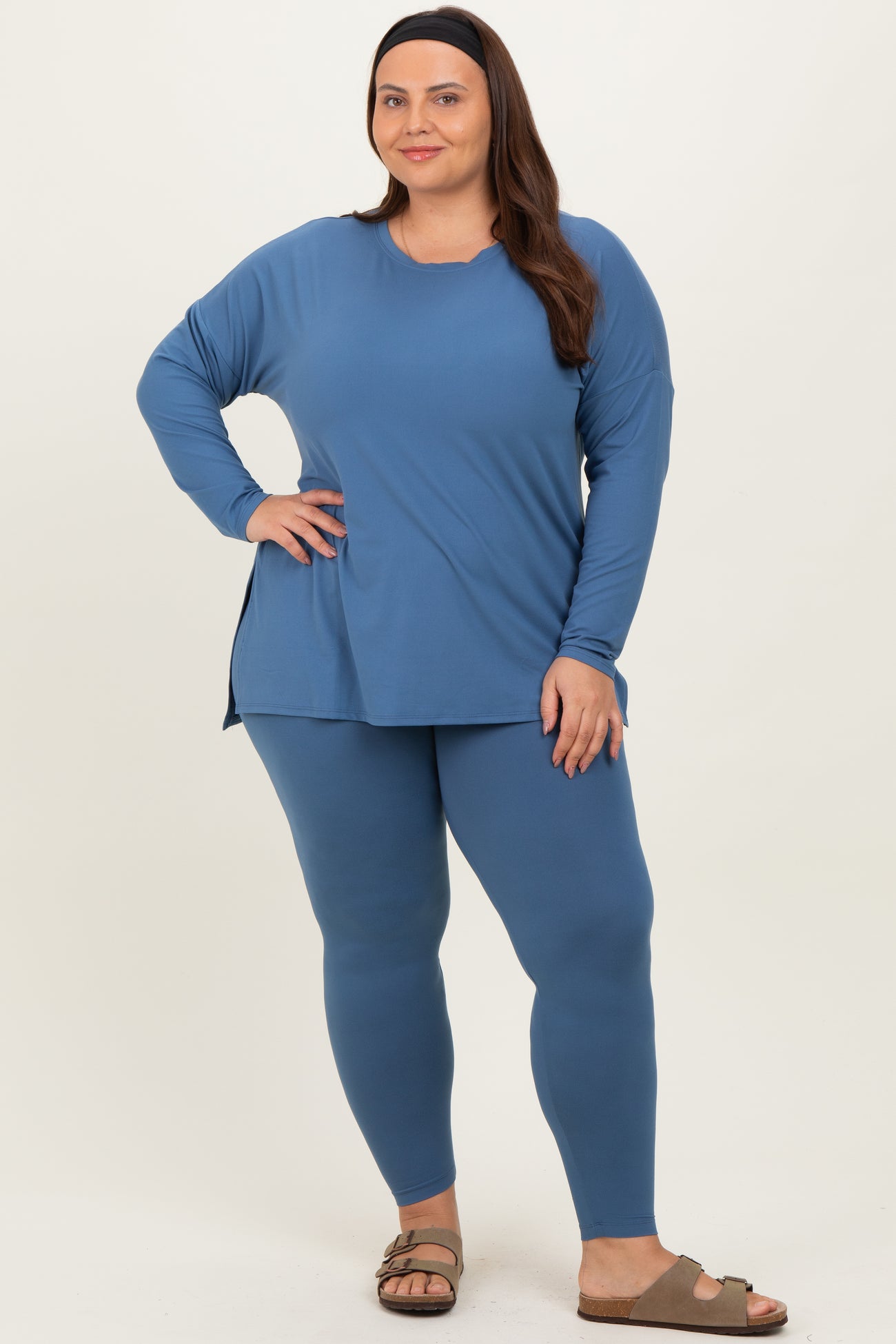 woman wearing a blue long sleeve top and matching leggings in a plus size fit