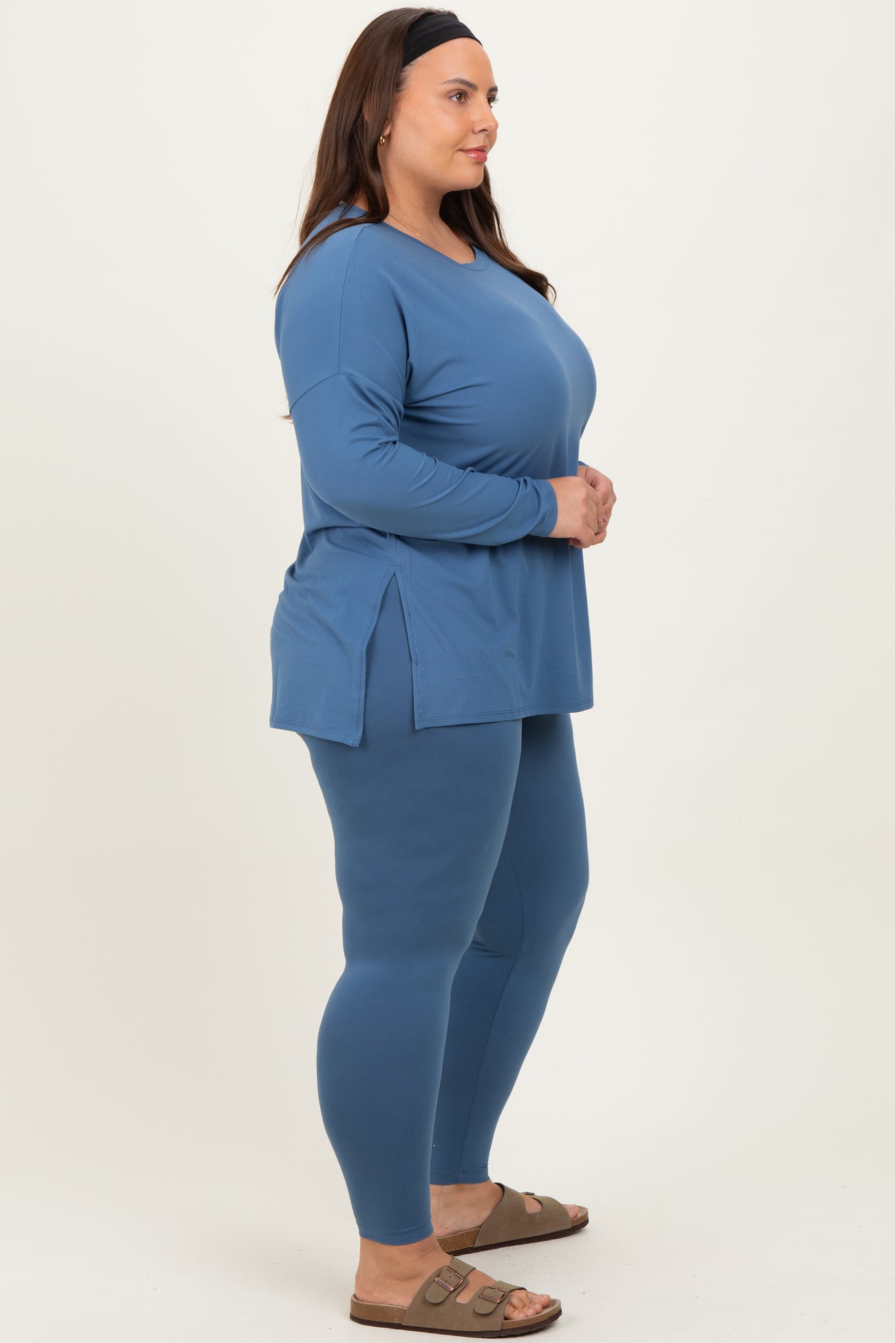 woman wearing a blue long sleeve top with side slits and matching leggings in plus size activewear style