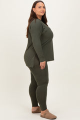 woman wearing an olive green long sleeve top and matching leggings, standing sideways with a relaxed fit
