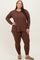 woman wearing a brown long sleeve top and matching leggings, styled for a comfortable look