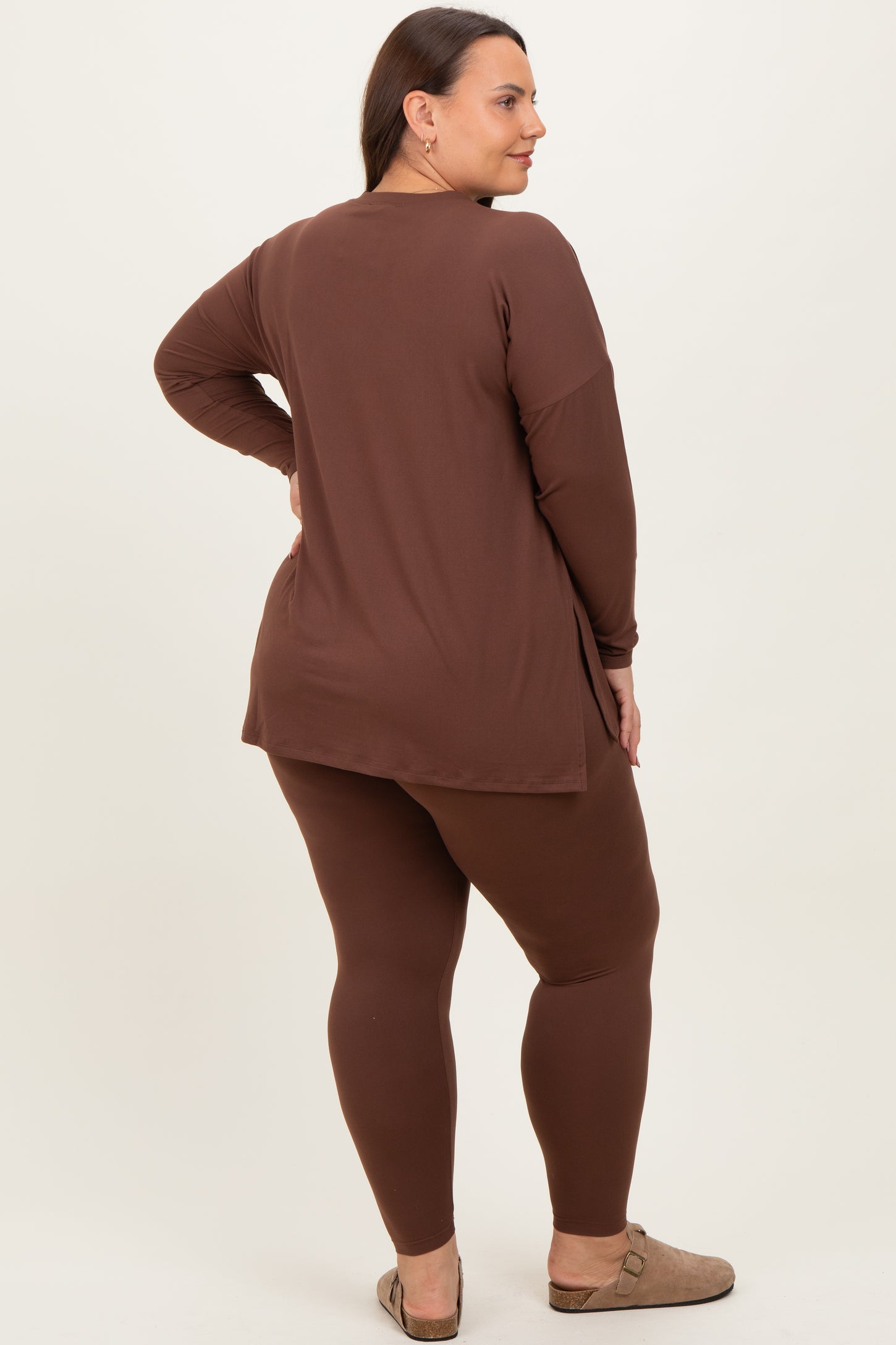 woman wearing a brown long sleeve top and matching brown leggings in a plus size fit