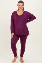 woman wearing a deep purple long sleeve maternity top and matching leggings, displaying her baby bump