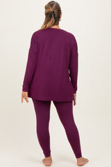 woman wearing a purple long sleeve maternity top and matching leggings, viewed from the back