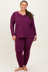 woman wearing a purple long sleeve top and matching leggings in plus size, standing with a smile