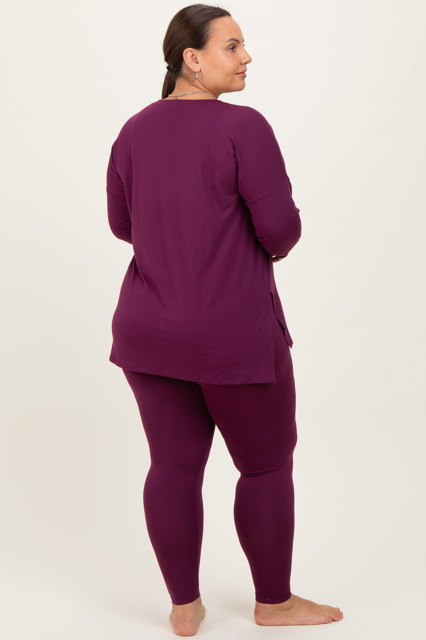 woman wearing a long sleeve purple top and matching leggings, showing a relaxed fit from the back
