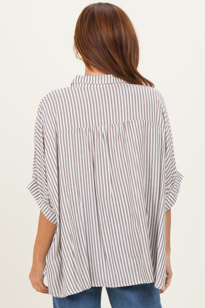 woman wearing a beige and white striped oversized button-up shirt with short sleeves