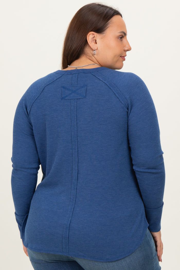 woman wearing a blue long sleeve plus size top with a back seam detail and a round neckline
