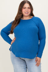 woman wearing a bright blue long sleeve maternity plus top with side slits and a relaxed fit