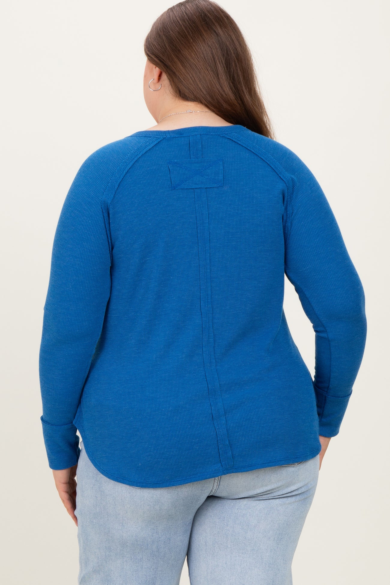 maternity plus woman wearing a blue ribbed long sleeve top with a back seam detail and relaxed fit