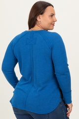 woman wearing a blue long sleeve plus size top with a back seam detail and round neckline