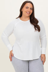 woman wearing a white long sleeve plus size shirt with a rounded hem and relaxed fit, posing with a smile