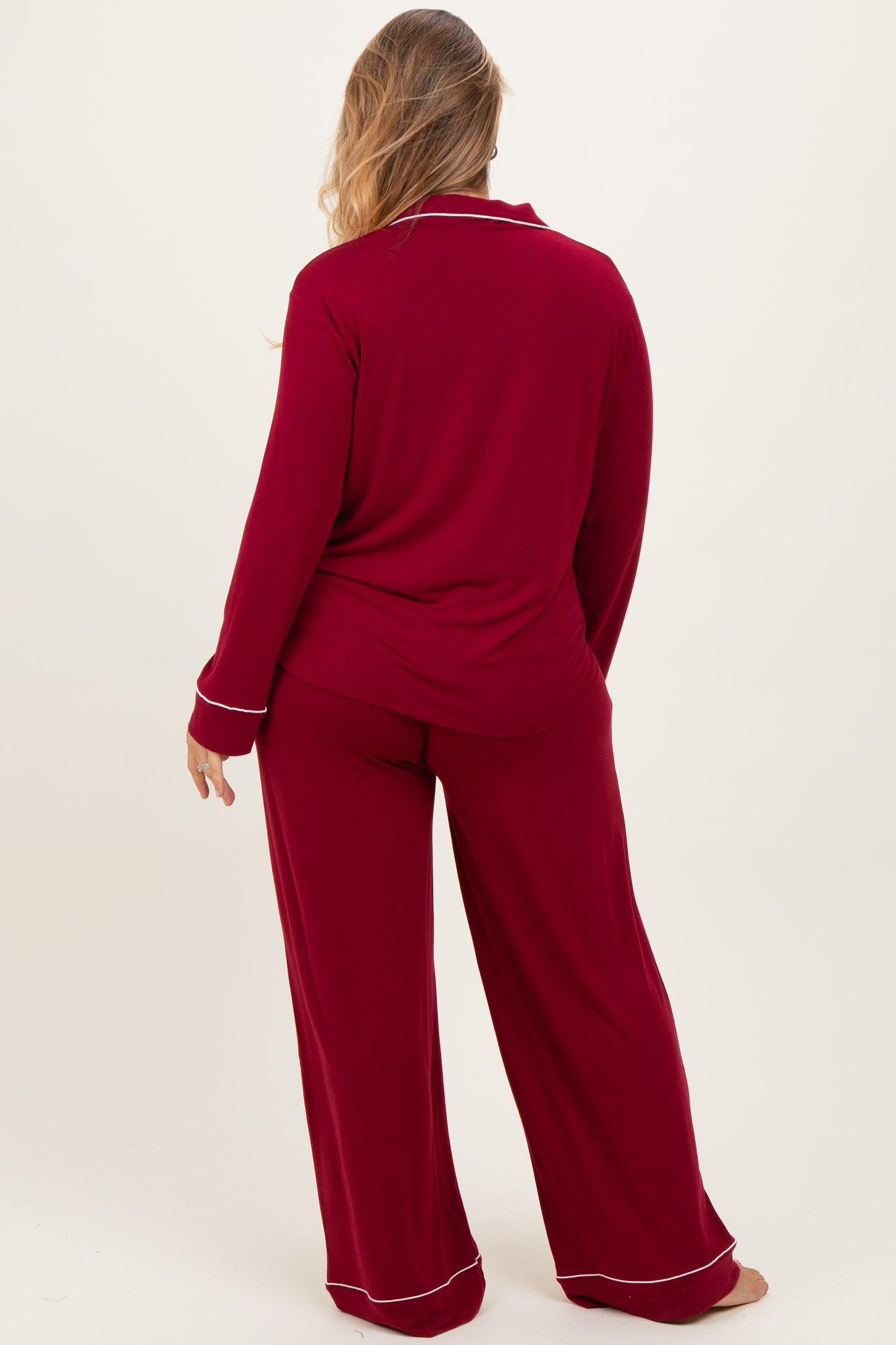 woman wearing a red maternity plus pajama set with long sleeves and wide-leg pants, viewed from the back