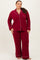 woman wearing a burgundy plus size pajama set with white piping, featuring a button-up top and wide-leg pants