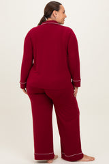 woman wearing a burgundy long sleeve pajama set with white piping, shown from the back