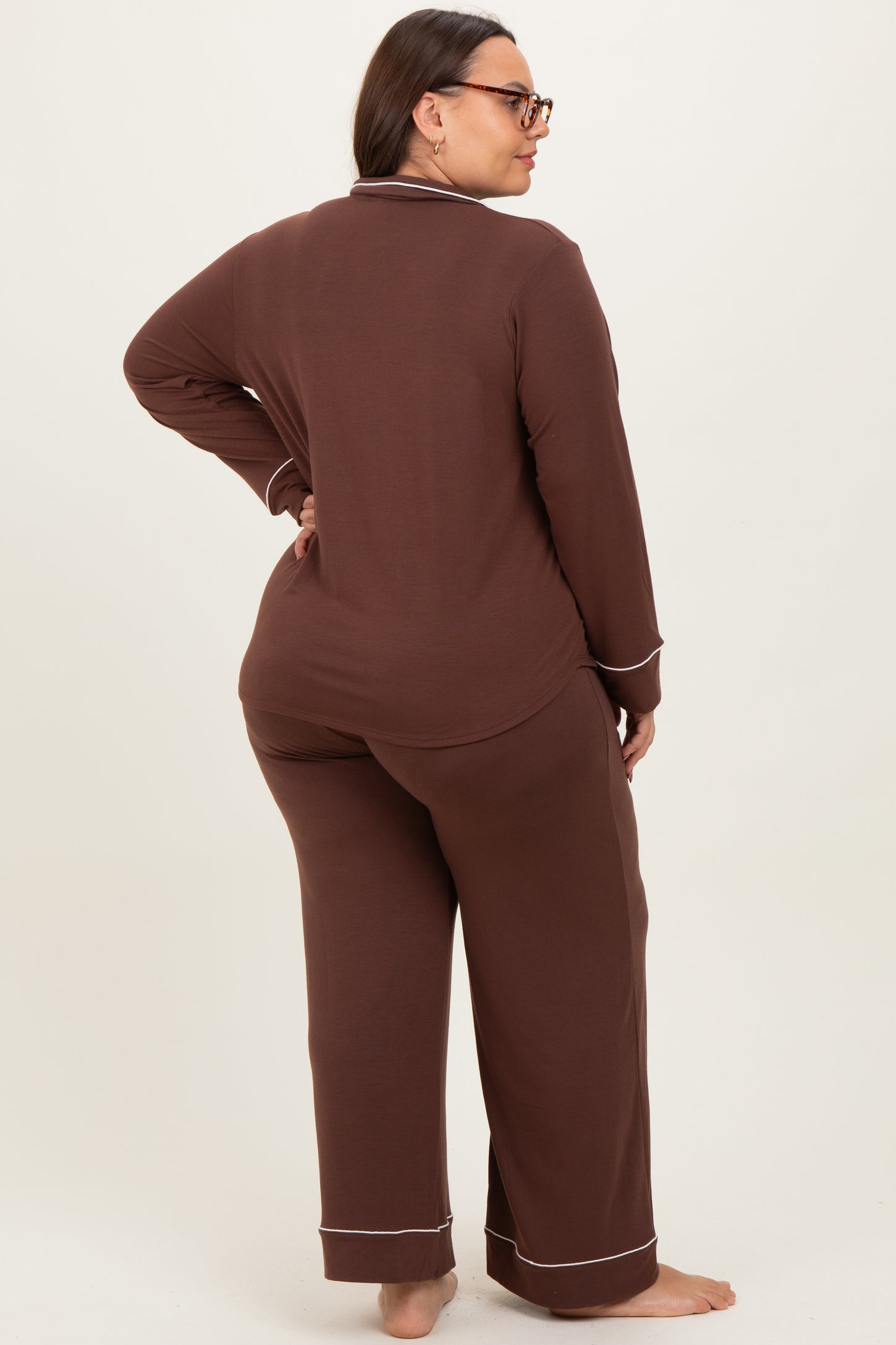 woman wearing a brown plus size pajama set with long sleeves and pants, shown from the back