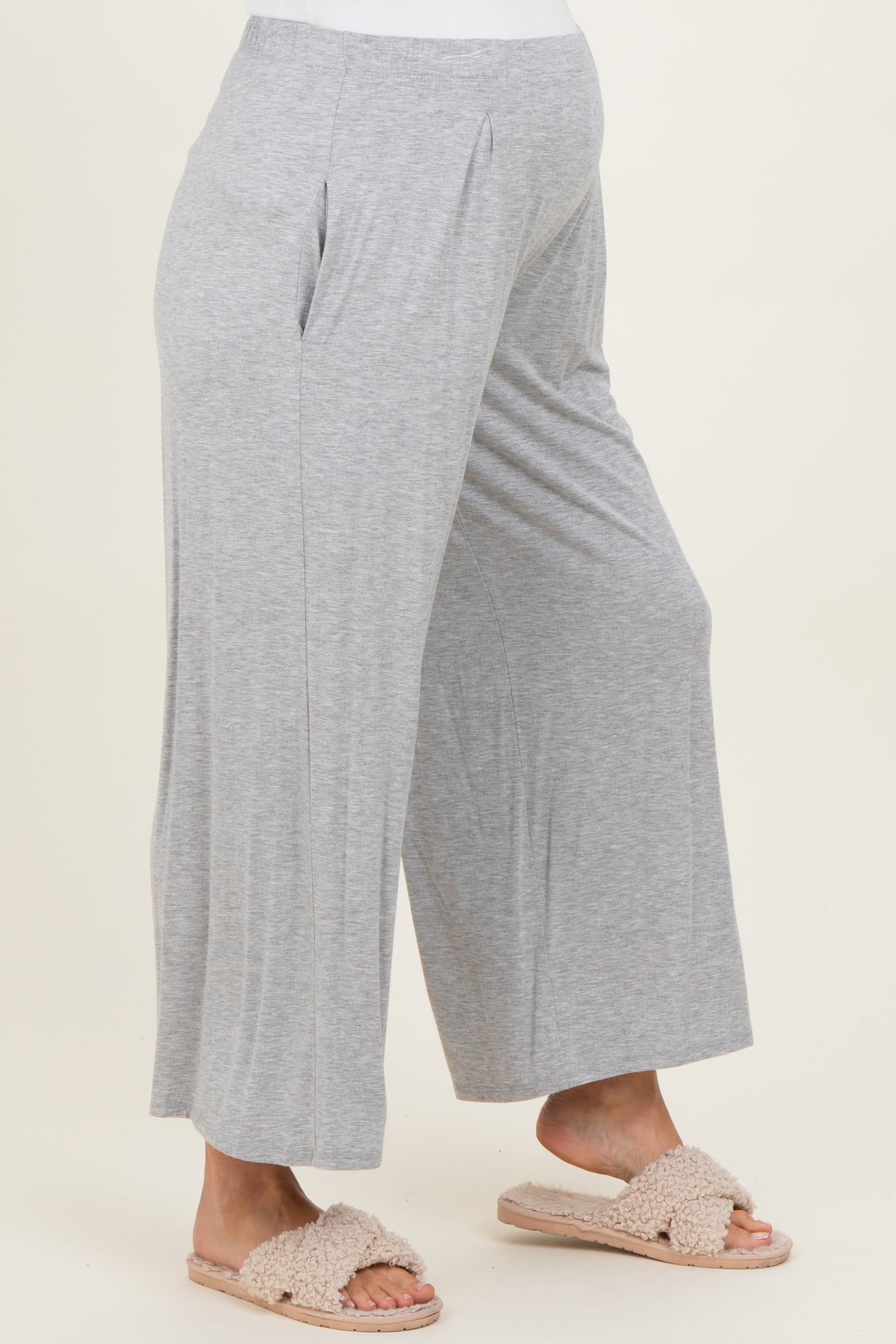 woman wearing gray maternity wide-leg pants with a comfortable waistband and a visible baby bump
