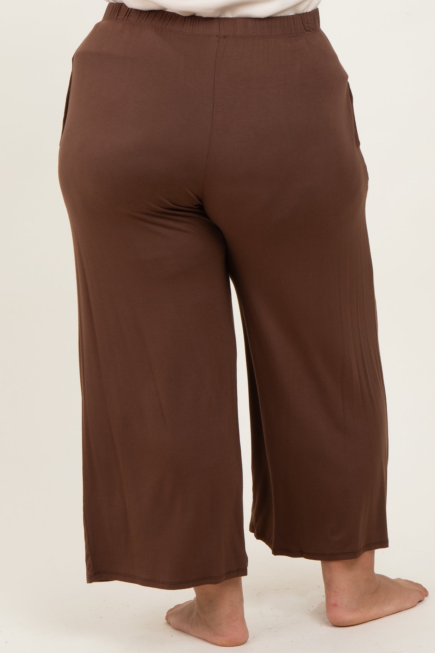 back view of woman wearing brown plus size culotte pants with side pockets