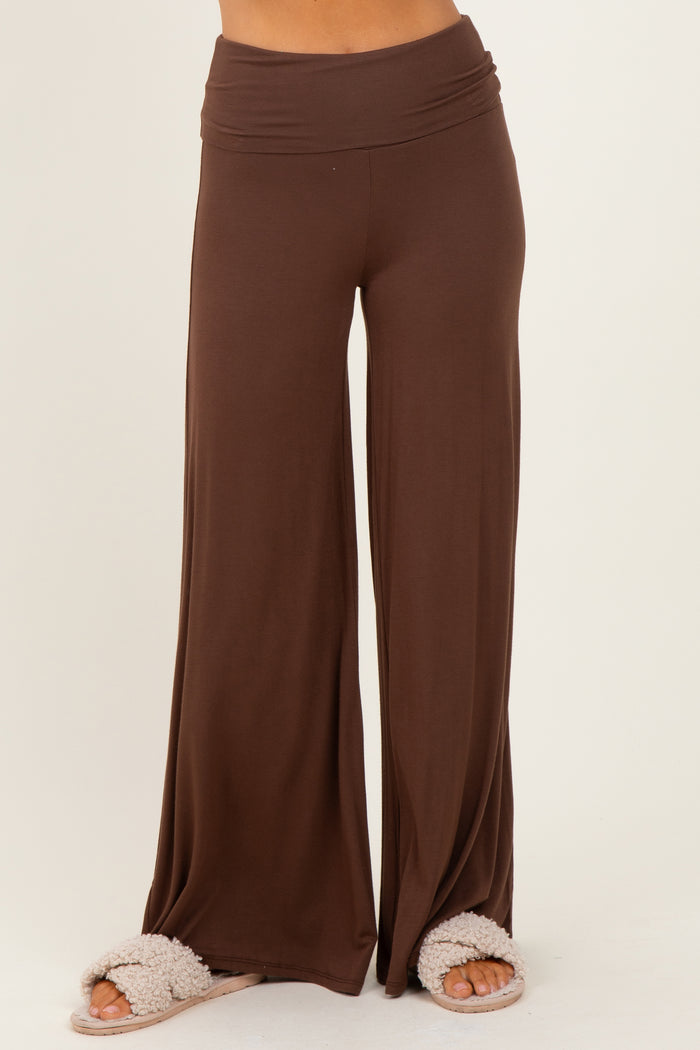 woman wearing brown wide-leg lounge pants with a comfortable waistband and fuzzy slippers