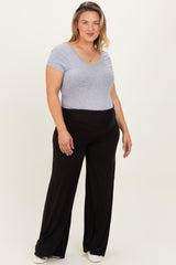 woman wearing a gray short sleeve maternity top and black flowy maternity pants, with a comfortable fit
