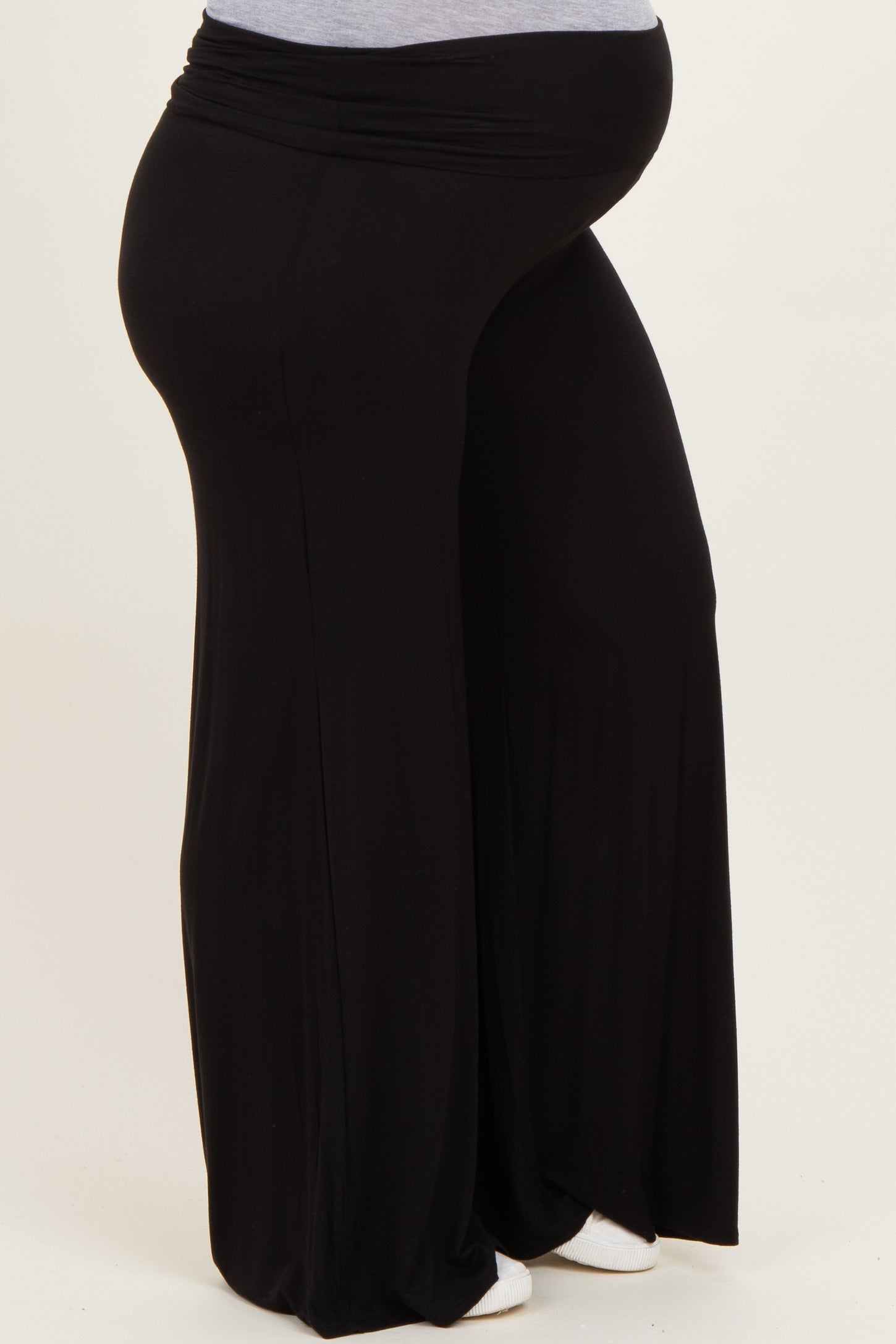 maternity wear in black wide-leg pants on a model showing a baby bump