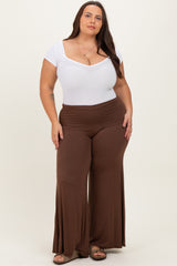 woman wearing a white short sleeve bodysuit and brown wide-leg pants