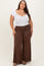 woman wearing a white short sleeve bodysuit and brown wide-leg pants
