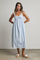 woman wearing a light blue midi dress with a ruching detail and spaghetti straps