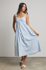woman wearing a light blue sleeveless maxi dress with a gathered bodice and flowy skirt