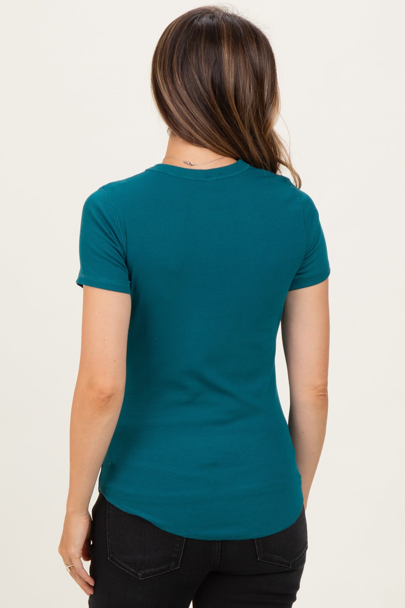woman wearing a teal maternity t-shirt with short sleeves and a curved hem, viewed from the back