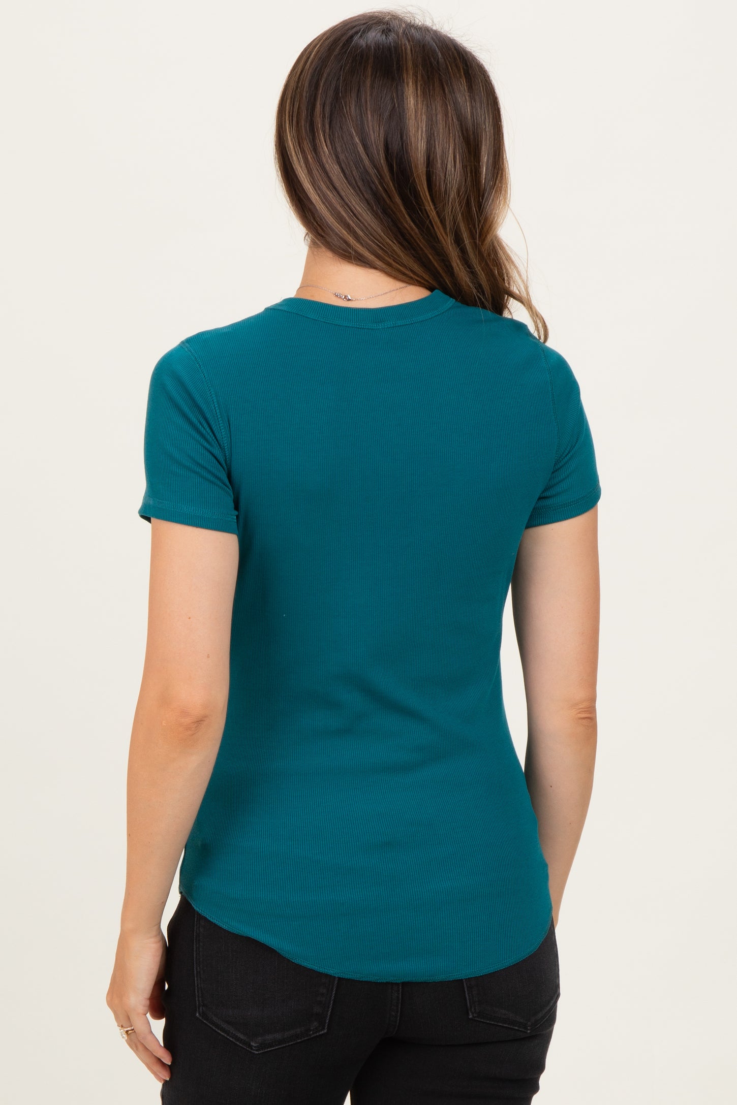 woman wearing a teal maternity t-shirt with short sleeves and a curved hem, viewed from the back