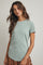 woman wearing a mint green short sleeve ribbed top with a round neckline, paired with a floral skirt