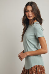 woman wearing a light green short sleeve top paired with a brown floral skirt