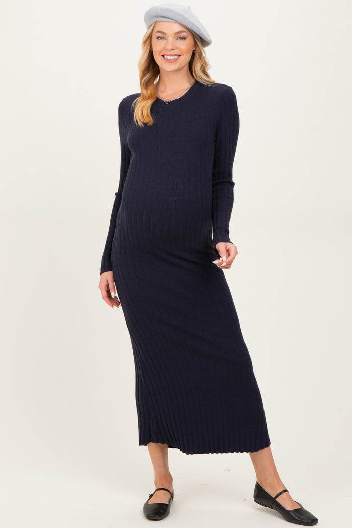 woman wearing a navy ribbed maternity maxi dress and a beret, showcasing her baby bump