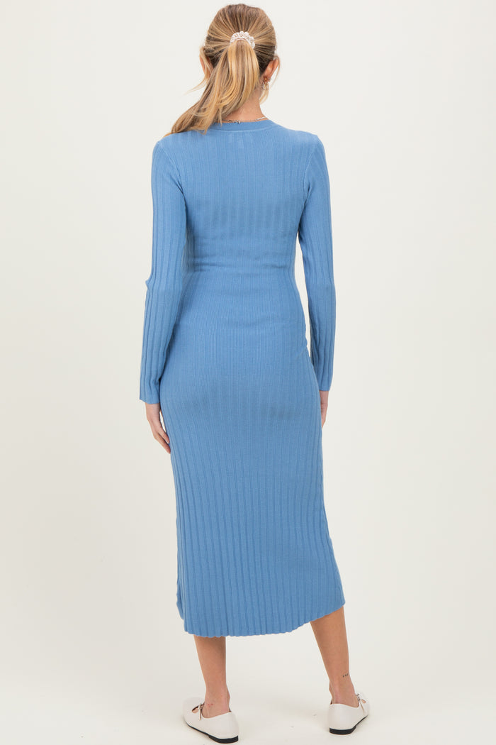 woman wearing a fitted ribbed baby blue maternity dress with long sleeves and a midi length, showing a baby bump