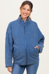 woman wearing a blue quilted maternity jacket with a high collar and side pockets