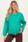 woman wearing a bright green maternity cardigan with buttons and a visible baby bump
