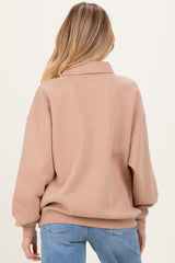 woman wearing a cozy beige maternity sweatshirt with a relaxed fit and drop shoulders