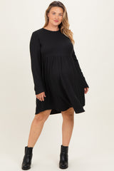 woman wearing a black long sleeve maternity dress with a swing silhouette, showcasing her baby bump