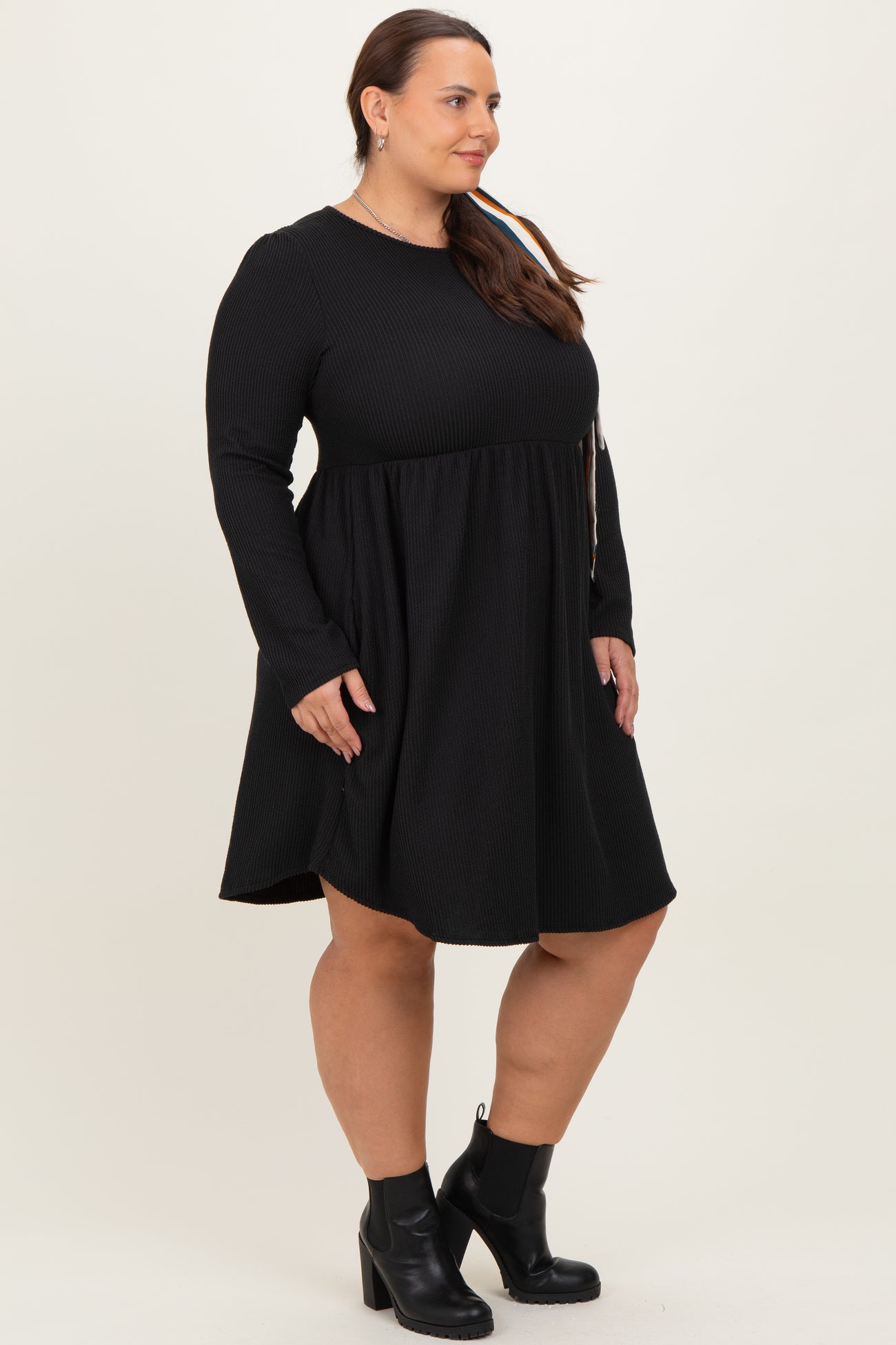 woman wearing a black long sleeve plus size dress with a flared skirt and ankle boots