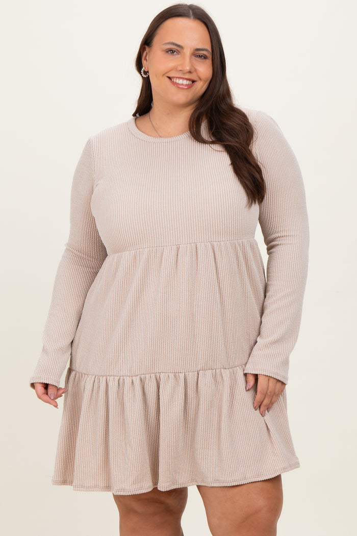 woman wearing a beige ribbed long sleeve plus size dress with a ruffled hem and a relaxed fit
