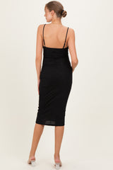 woman wearing a black sparkly maternity bodycon dress with spaghetti straps and ruched detail from the back