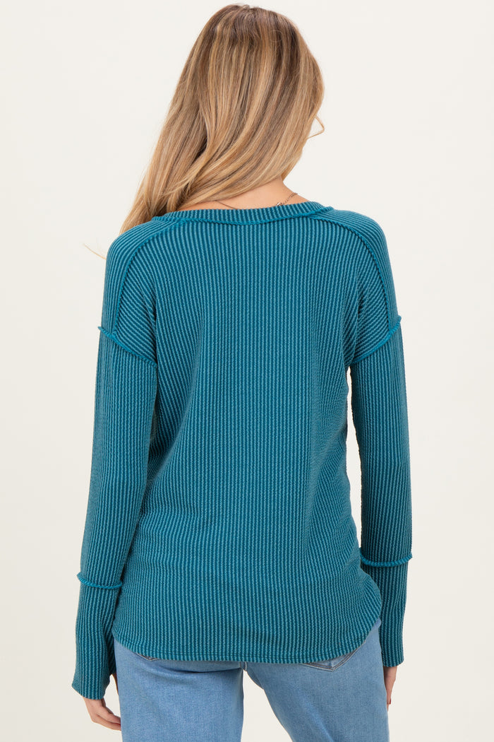 woman wearing a teal ribbed long sleeve maternity sweater views the back, with relaxed fit and side slits