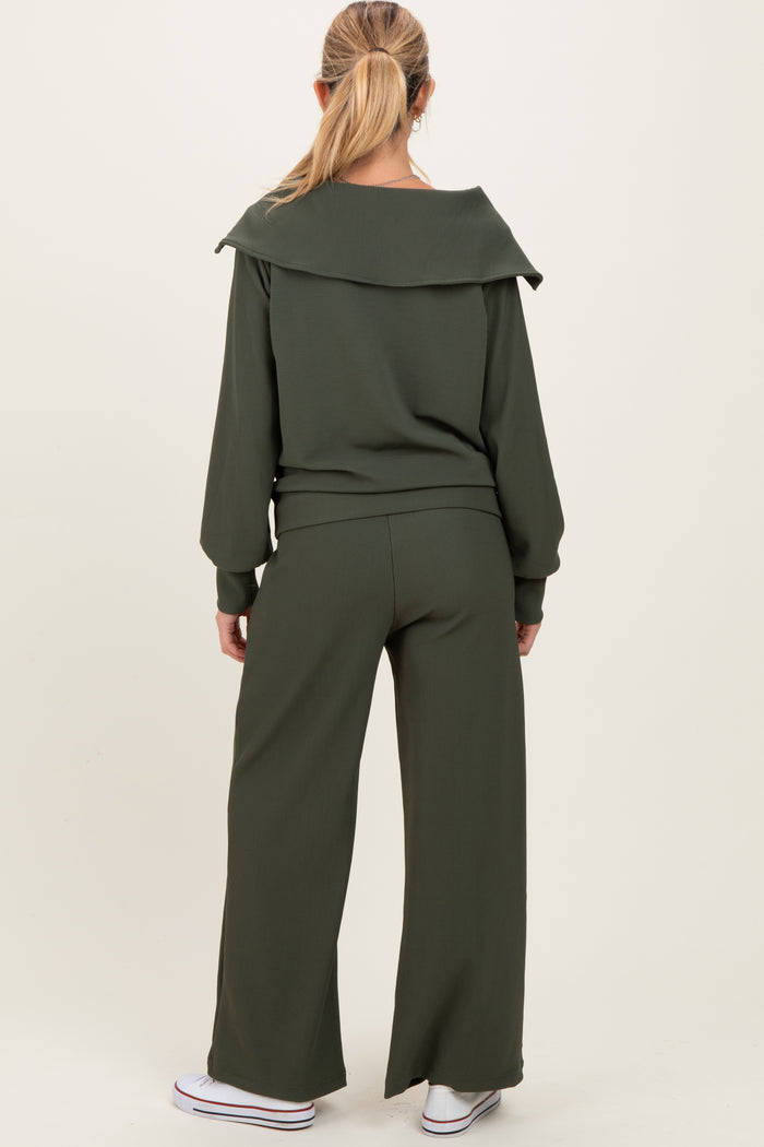woman wearing a ribbed dark green maternity lounge set with a relaxed fit and wide-leg pants, viewed from the back