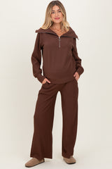 woman wearing a brown maternity loungewear set with a zip-up top and wide-leg pants, featuring a relaxed fit