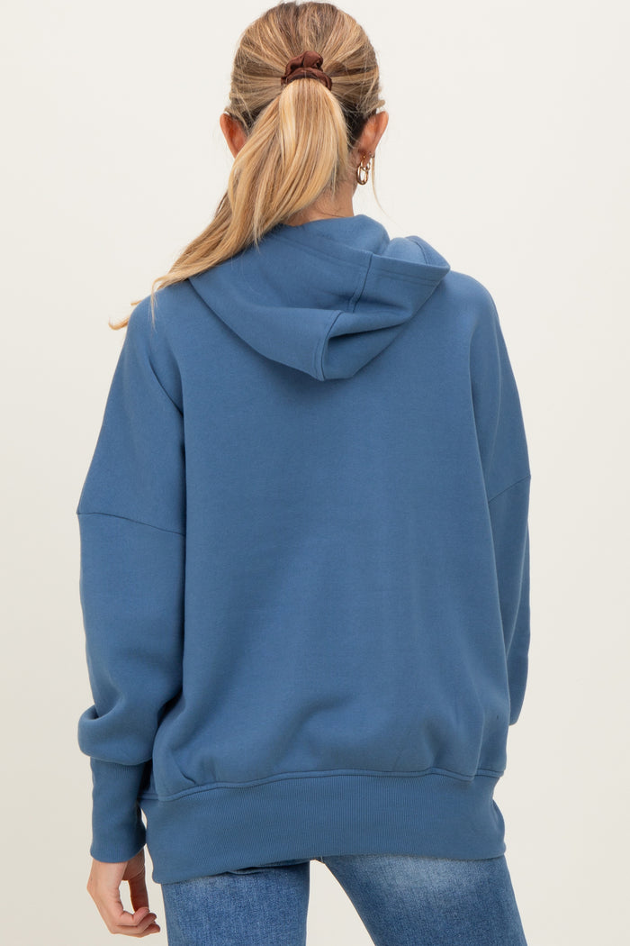 woman wearing a blue oversized maternity hoodie, seen from the back, with a hood and long sleeves