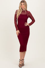 woman wearing a burgundy lace midi dress with long sleeves and a fitted silhouette